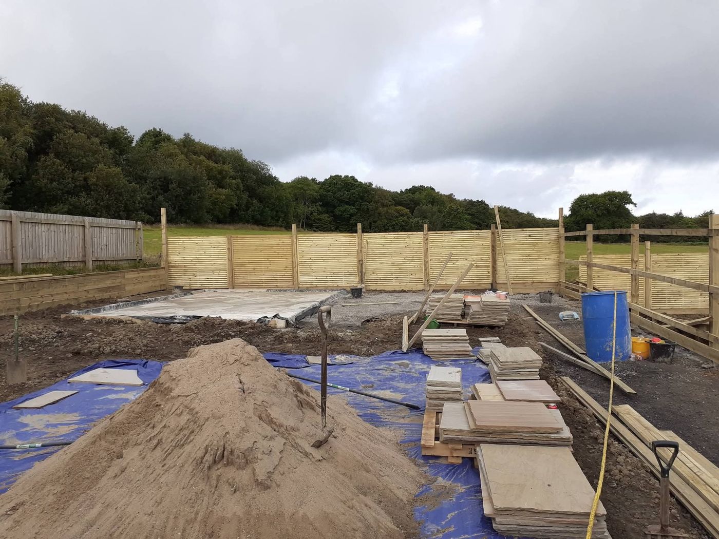 New timber fencing being installed around a garden with posts and panels in place