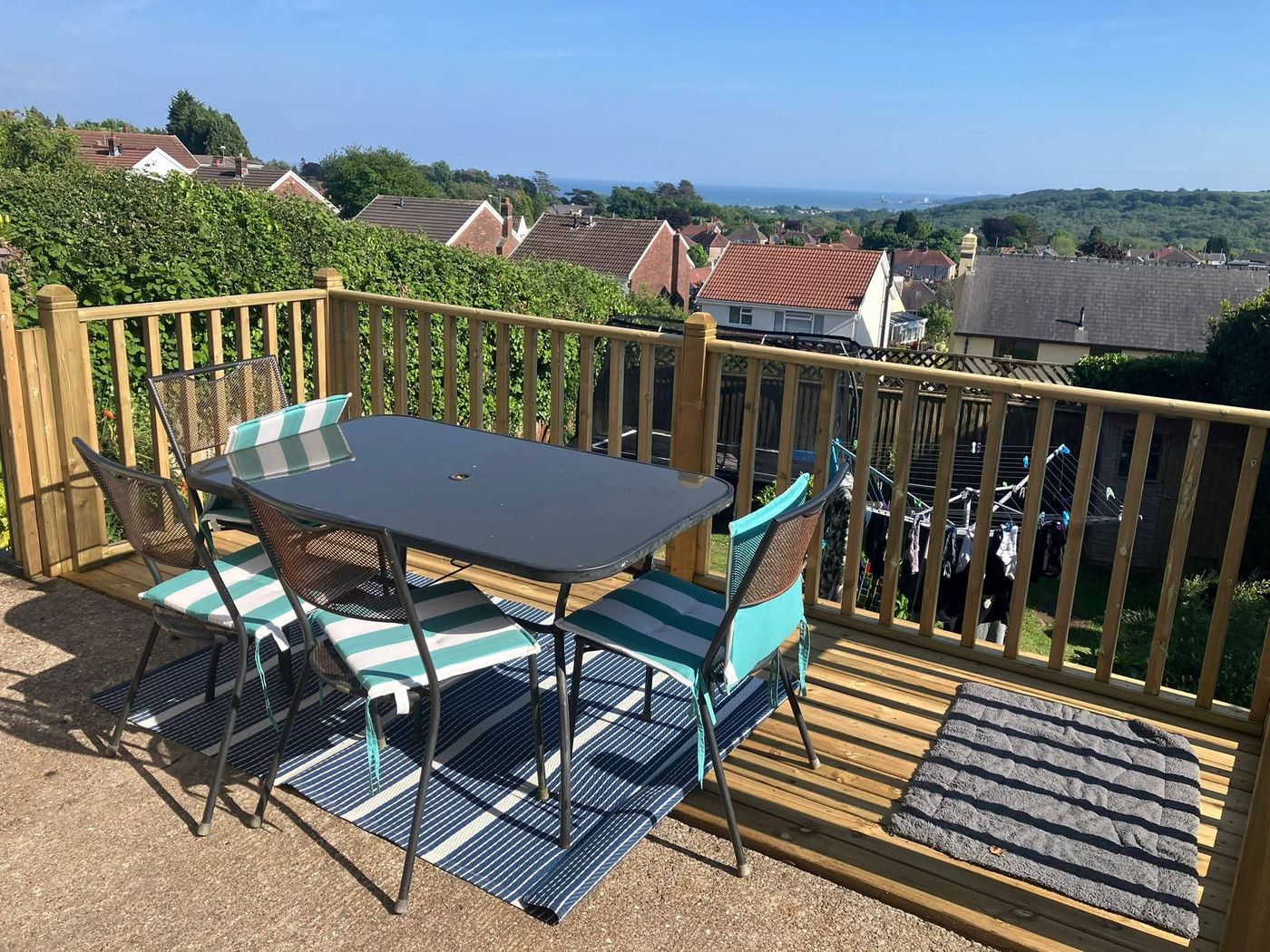 Timber decking with balustrade and garden furniture overlooking rooftops