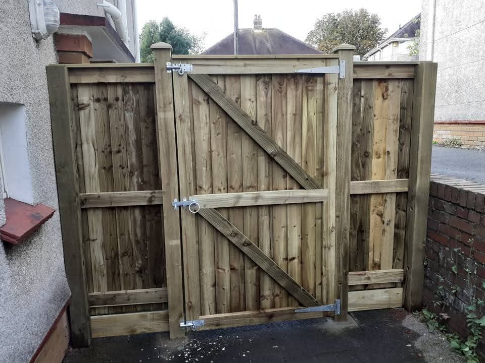 Timber garden gate with galvanised hinges fitted between fence panels